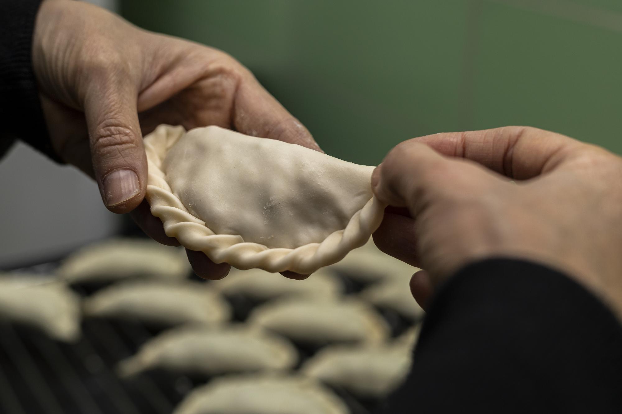 Detal: ręce formujące pierogi